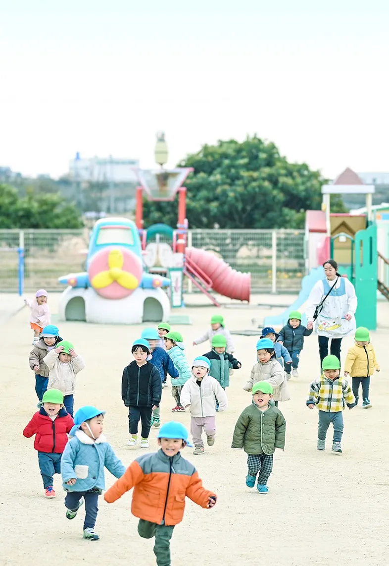 柊山さくらの木保育園の園庭で子供達が楽しそうに遊んでいる写真